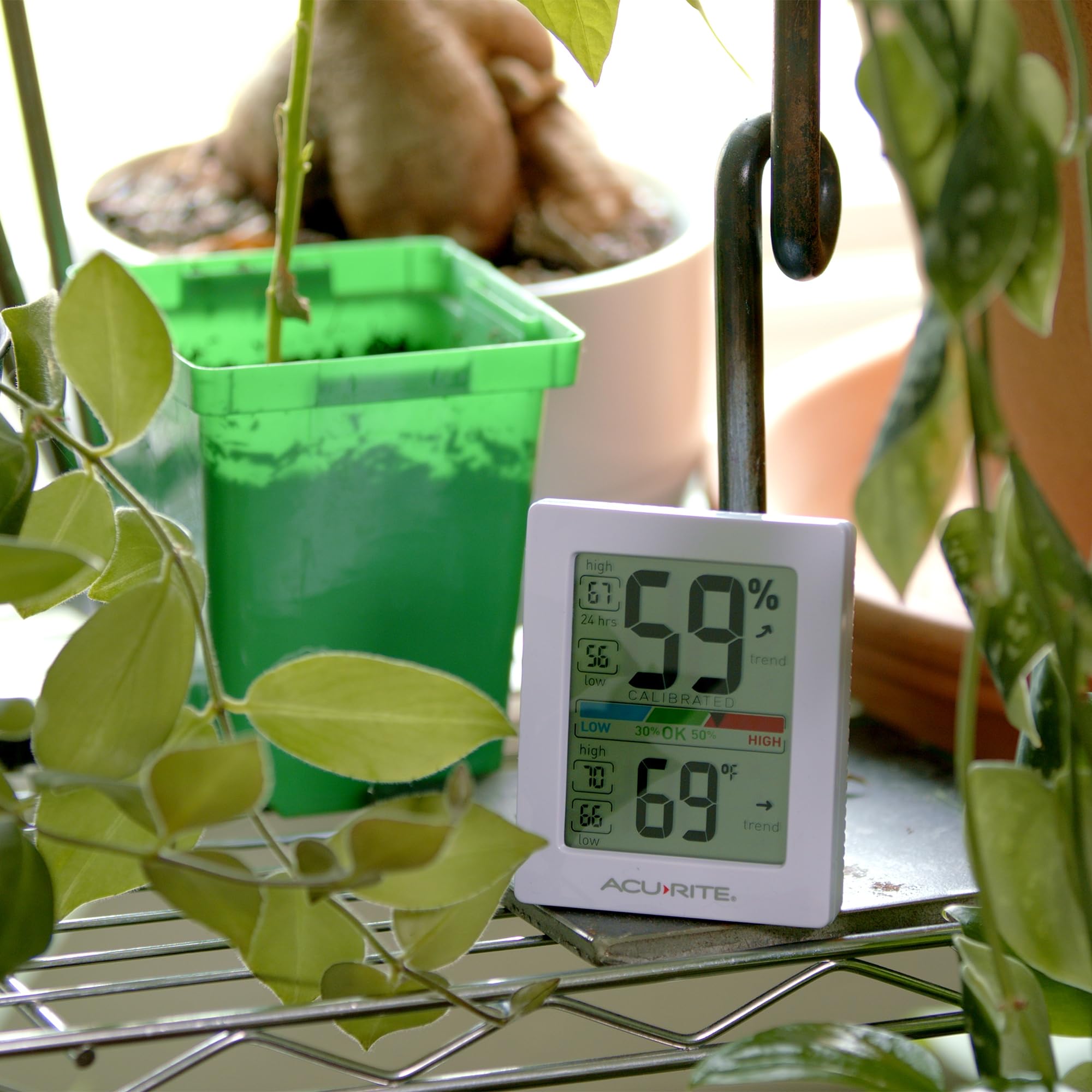 AcuRite comparado con una mano para mostrar tamaño compacto