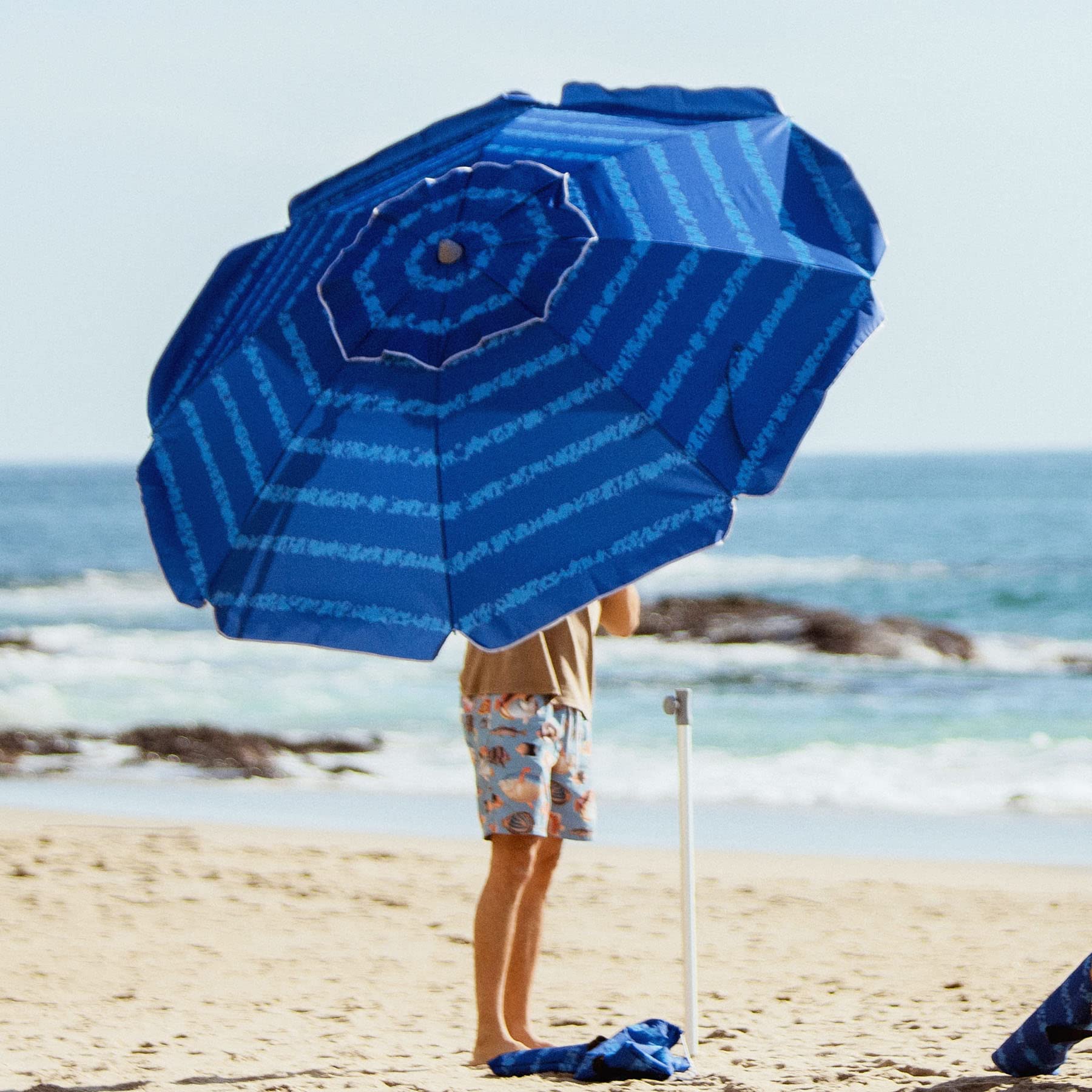 AMMSUN sombrilla en la playa dando sombra a una familia relajada