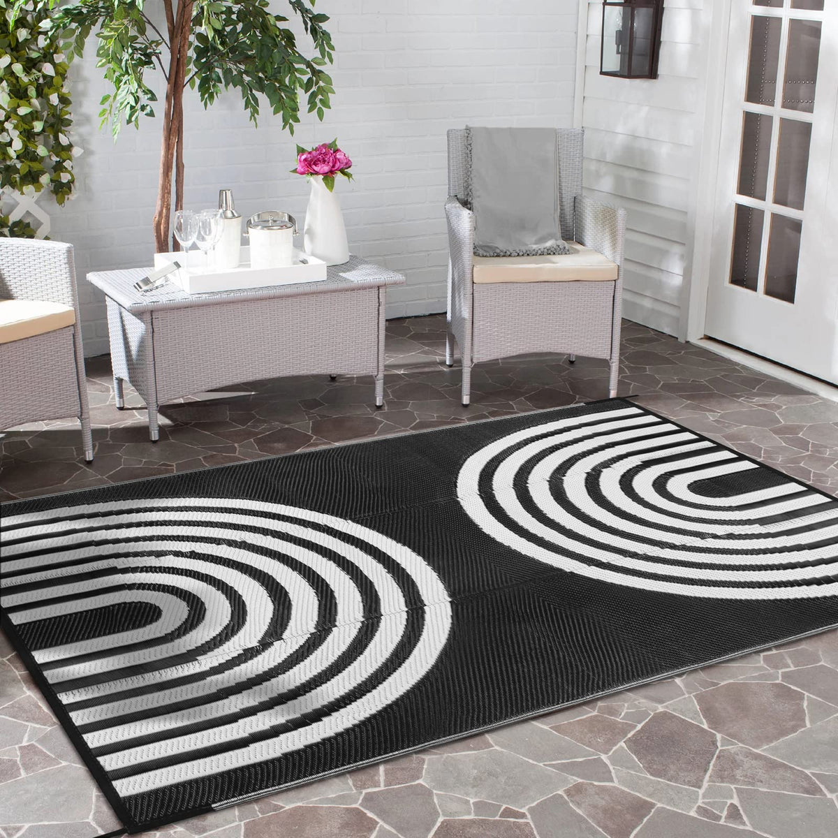 Anidaroel alfombra exterior frontal mostrando diseño blanco y negro, mejora estética del patio