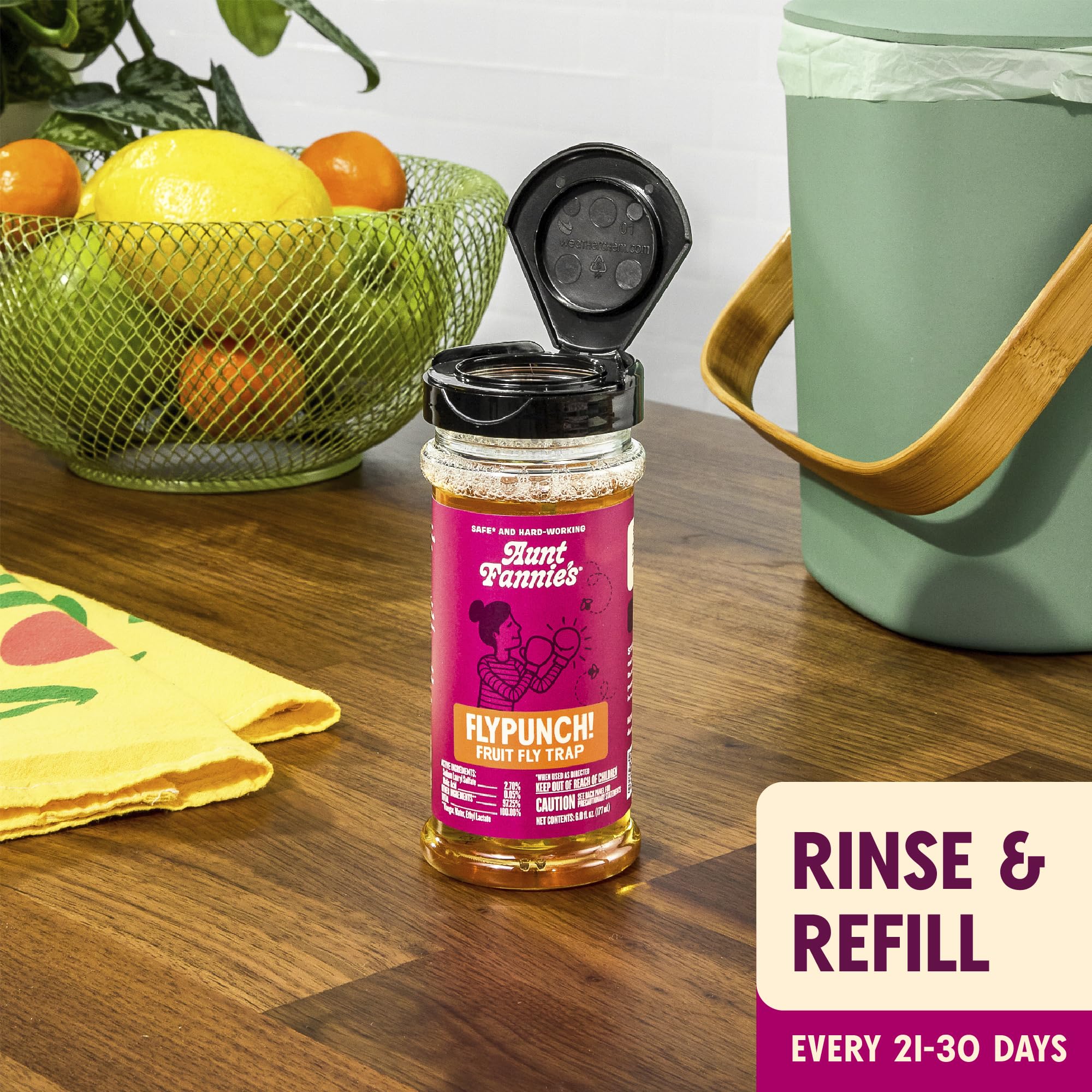 Aunt Fannie's envase de 32 oz al lado de una mano para mostrar escala