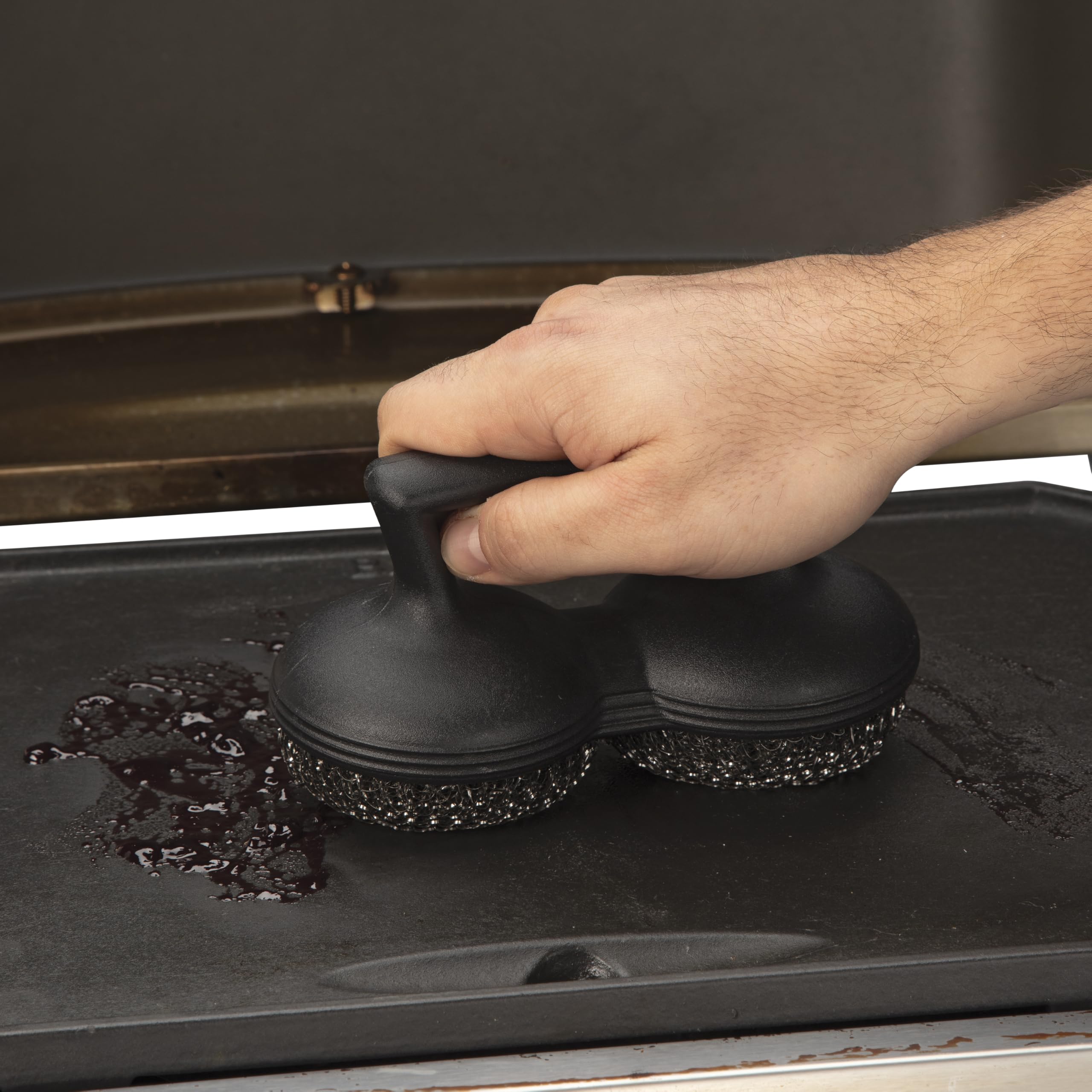 Cuisinart Power Scour junto a una mano para comparar tamaño y control