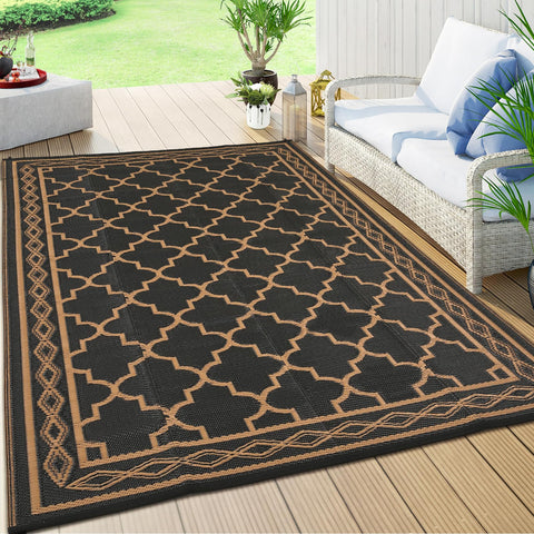 Garvee alfombra desplegada junto a un RV creando zona exterior cómoda