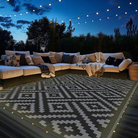 GENIMO alfombra exterior vista frontal mostrando diseño gris oscuro y patrones geométricos