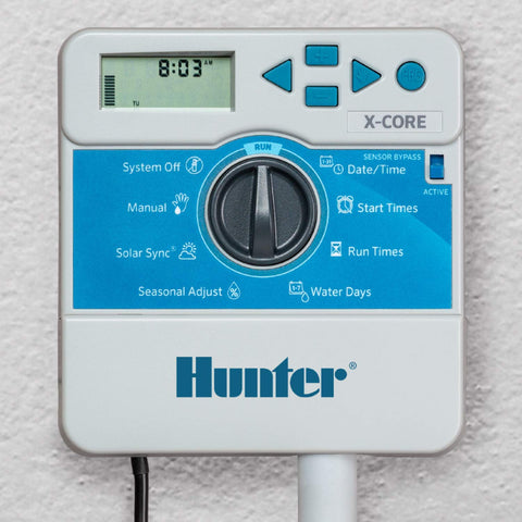 Hunter X-Core XC600i instalado en garaje controlando seis zonas, ahorro de agua