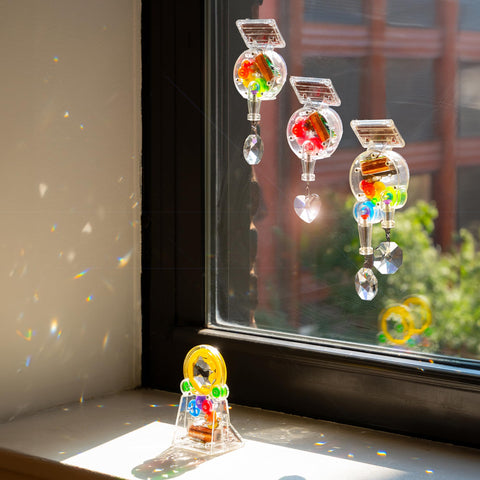 Kikkerland instalado en una ventana con luz solar, crea patrones luminosos dentro de la habitación