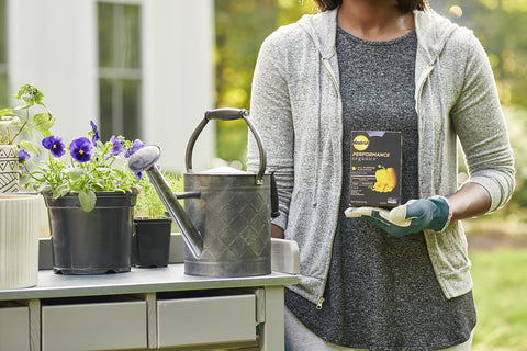 Miracle-Gro en uso con regadera aplicando alimento natural a cultivos