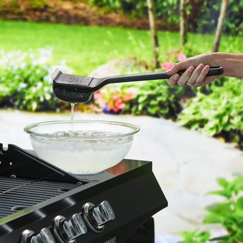 Mr. Bar-B-Q cepillo en uso sobre parrilla caliente, reduce esfuerzo