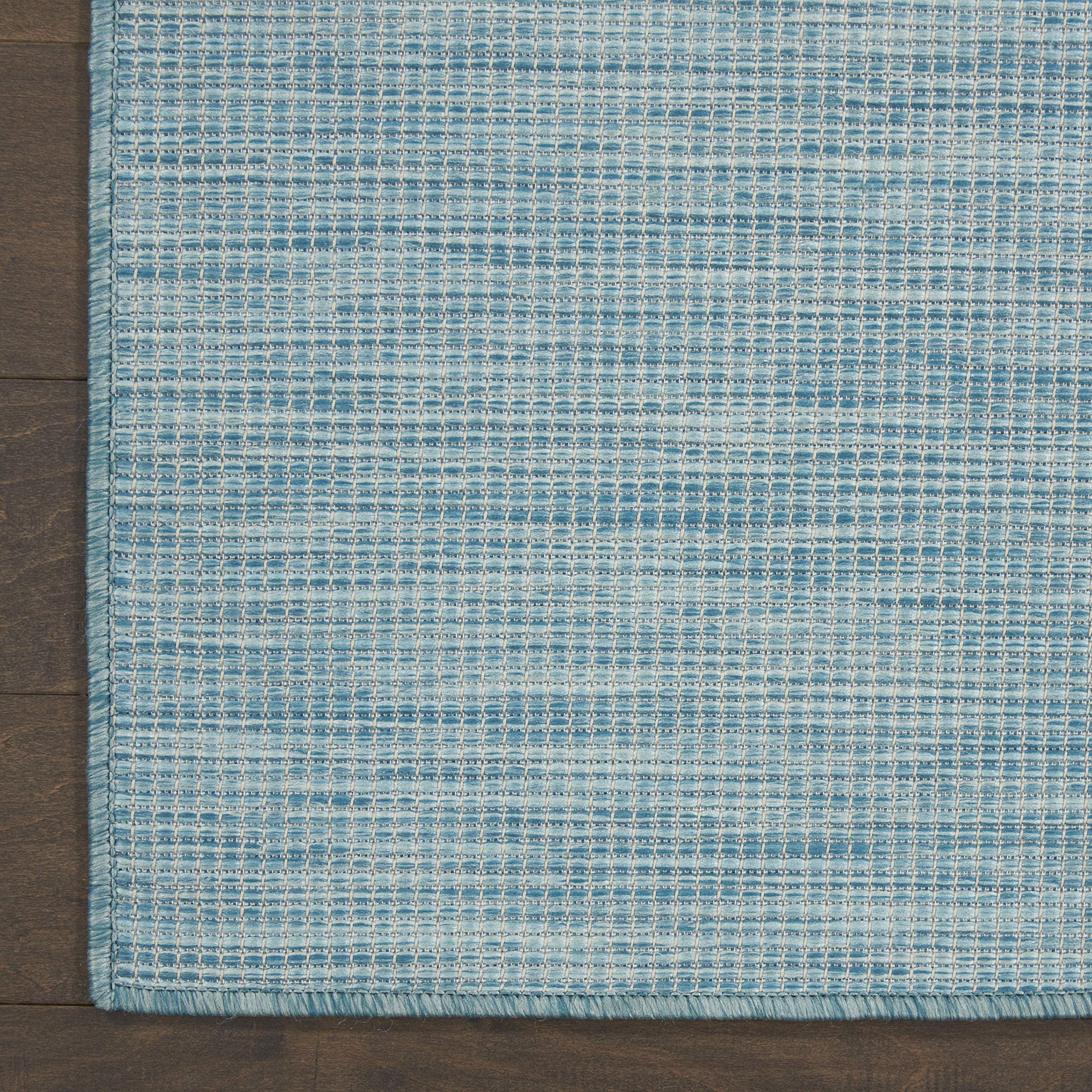 Nourison Positano Aqua colocada bajo mesa de comedor protegiendo el suelo