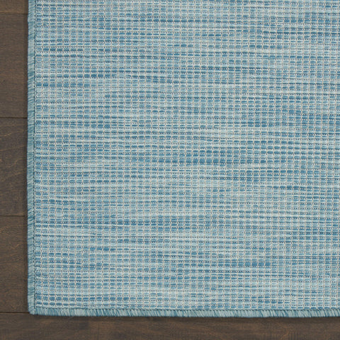Nourison Positano Aqua colocada bajo mesa de comedor protegiendo el suelo