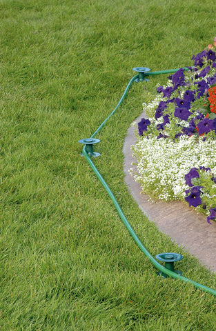 Orbit guía colocada en jardín canalizando manguera para proteger plantas