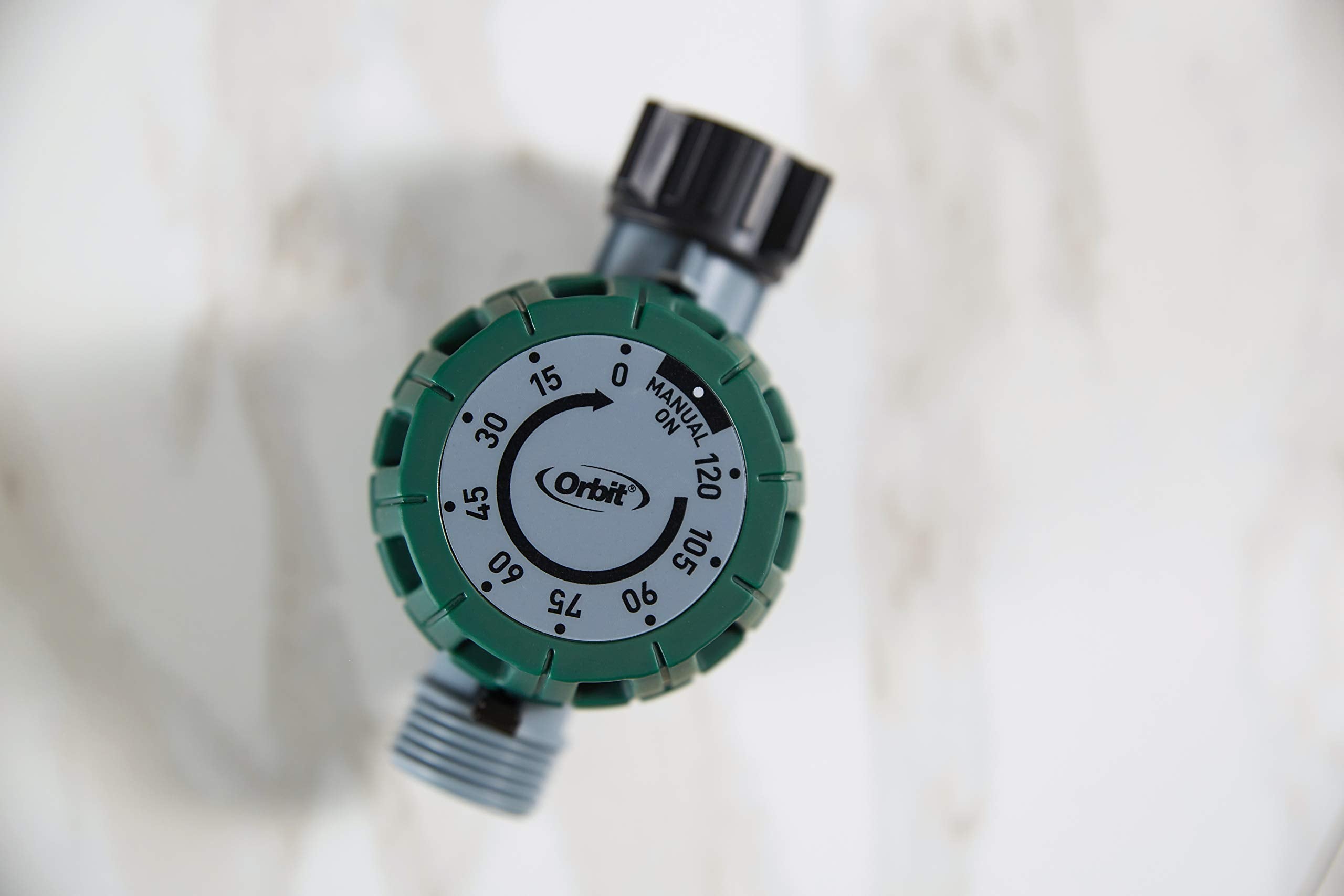 Orbit temporizador alimentando un aspersor, optimiza el riego del césped