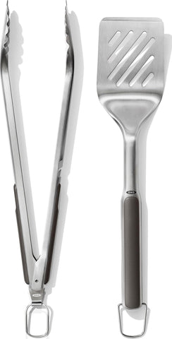 OXO espátula y pinzas frontal mostrando diseño y uso cómodo