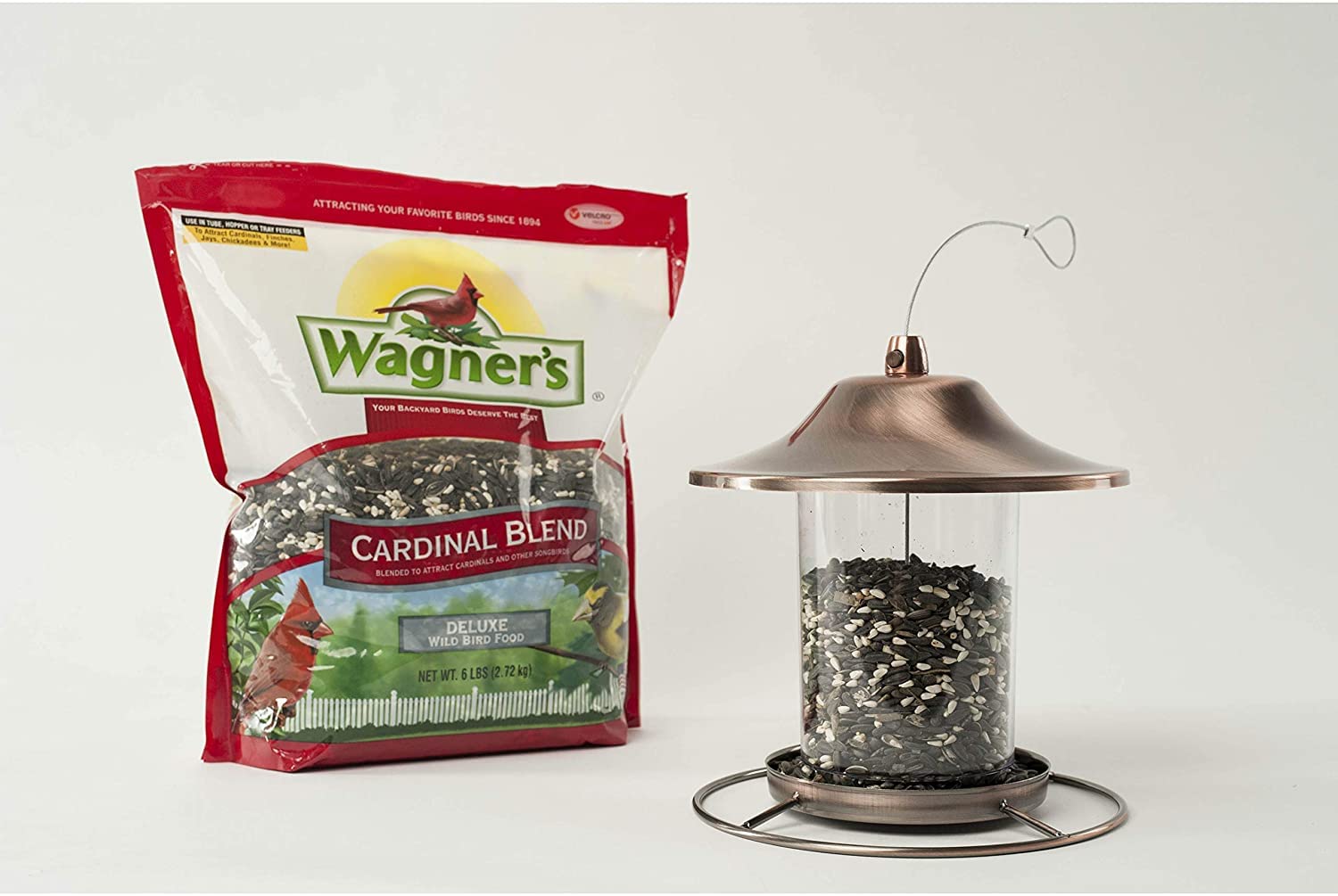 Wagner's comedero en jardín con arbustos y aves, crea ambiente ideal para visitantes