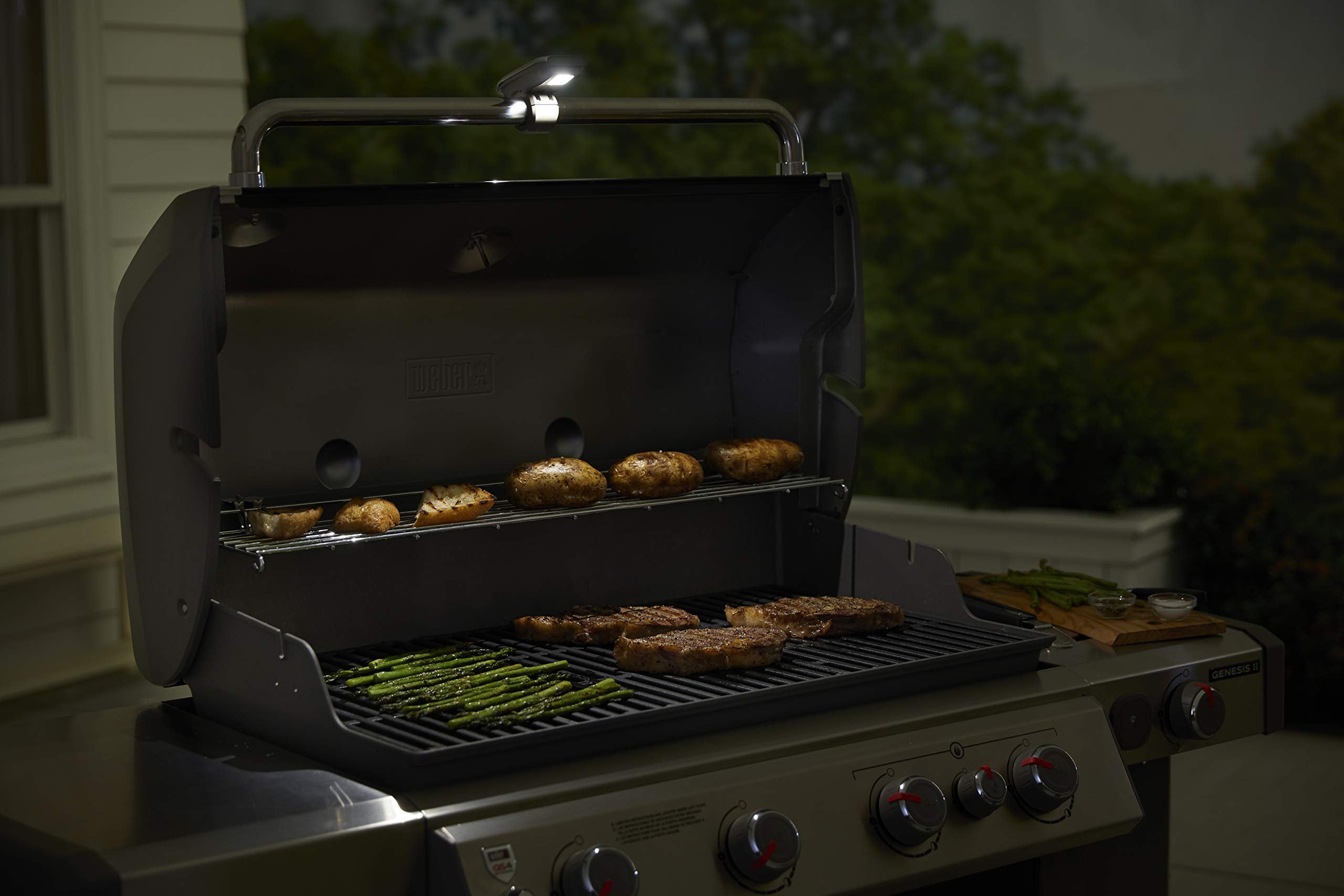 Weber foto lifestyle nocturna con parrilla iluminada y ambiente seguro
